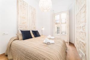 马拉加Suite Homes Uncibay Square的一间卧室配有一张大床和两条毛巾
