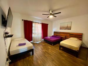 坎昆Cancun-Soho的客房设有两张床和吊扇。