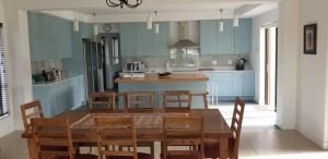 西萨默塞特Modern spacious home in heart of Cape Winelands的厨房配有蓝色橱柜和桌椅