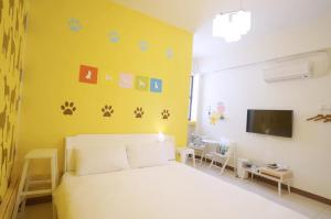 恒春古城隨緣民宿 Suiian inn的卧室配有白色的床和黄色的墙壁