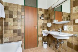 巴特特尔茨科尔比加顿酒店的一间带水槽和镜子的浴室