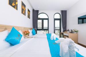 岘港Euro Star Riverside Hotel的卧室配有带蓝色枕头的大型白色床