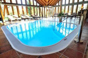 赫斯巴赫韦贝尔霍夫城堡酒店的一座带椅子的大型游泳池