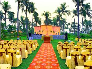 普里Toshali Sands Nature Escape Puri的一个带椅子的宴会厅和红色及黄色的地毯
