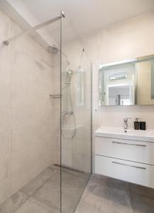 苏佩塔尔Apinelo的一间带玻璃淋浴和水槽的浴室