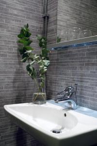 桑德维肯斯科姆玛斯加登霍格博酒店的浴室水槽,花瓶里装有植物