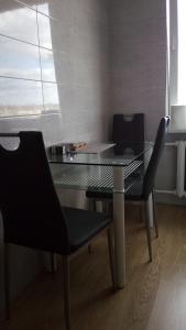 帕内韦日斯Bright apartment on top的玻璃桌和两张黑椅子