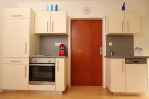 ScheiflingHH-Apartments的厨房配有白色橱柜和棕色门