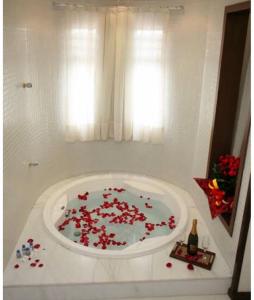 卡达斯诺瓦斯Apartamentos Caldas Novas的浴室配有装满红花的浴缸。