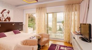 布德瓦子午线酒店的一间卧室设有一张床、一台电视和一个窗口。