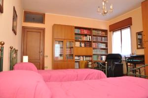 伦德吉安格洛住宿加早餐旅馆的一间设有粉红色床铺和书架的房间