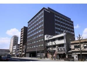 京都Richmond Hotel Premier Kyoto Ekimae的一条城市街道上高大的黑色建筑