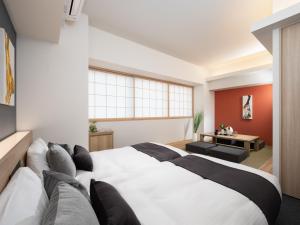 东京MIMARU TOKYO SHINJUKU WEST的卧室配有一张白色的大床和一张沙发。