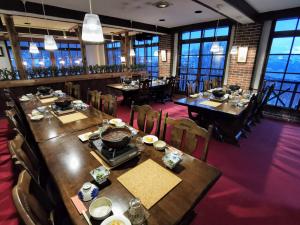 饭山市Fujio Pension Madarao Apartment Hotel & Restaurant的用餐室设有桌椅和窗户。