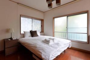 东京Annex Shibuya的卧室配有白色床和2扇窗户