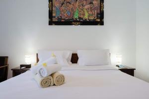 乌鲁瓦图WIRA Homestay & Spa的卧室配有白色床和毛巾