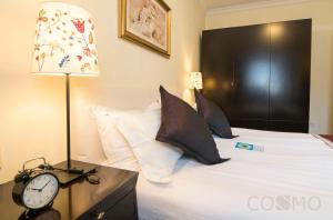 上海国际丽都公馆的一间卧室配有一张带时钟和灯的床