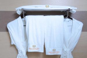 达累斯萨拉姆Tiffany Diamond Hotels Ltd - Indira Gandhi street的毛巾架上悬挂的一组白色毛巾
