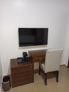 伊凯贾Presken Residence Annex的一张桌子、椅子和墙上的电视