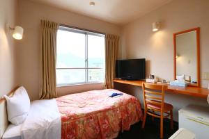 熊野市见晴亭商务酒店的配有一张床、一张书桌和一扇窗户的酒店客房