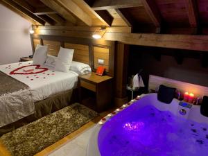 SaroAkla Hotel Suites Valles Pasiegos的一间卧室配有一张床和浴缸