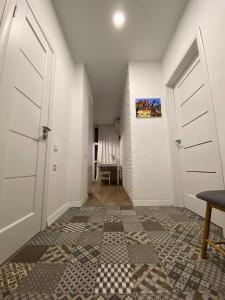 克里扎尼夫卡Scandinavian apartment на Марсельской的走廊设有白色门,铺有瓷砖地板