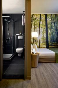 亨克Hotel Zuid的一间卧室设有一张床、淋浴和卫生间