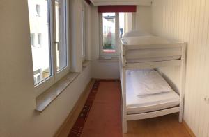 代特莫尔德Apartmenthaus Am Bahnhof的一间小房间,设有一张双层床,位于窗户旁