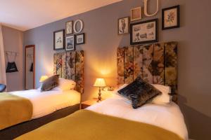 彻特西皇冠酒店的卧室配有两张床,墙上挂有图片