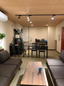 奈良Hilo Hostel的客厅配有沙发和桌子