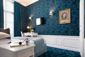 巴黎Odeon Hotel by Malone的客厅设有一张床和蓝色的墙壁