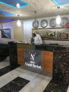 伯萨汉柯大酒店的一间墙上挂有时钟的餐厅和一个柜台