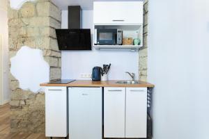 库雷萨雷Südalinna apartment的厨房配有白色橱柜和水槽