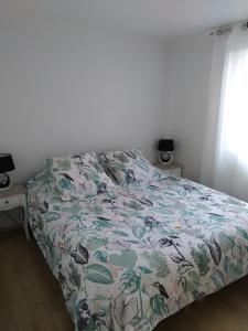OeyreluyGîte de l'Aiguille的一间卧室配有一张带花卉床罩的床