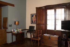 苏克雷波萨达精品酒店的客厅配有书桌和电视。