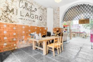 普埃布拉Milagro Hotel的餐厅设有木桌和砖墙