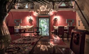 帕伦克金塔夏娜布娜精品酒店的一间拥有红色墙壁和桌椅的用餐室