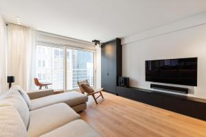 奥斯坦德Hyper-Luxeappartement, zeezicht, centrum, airco, optie hotelservices的带沙发和平面电视的客厅
