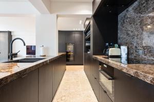 奥斯坦德Hyper-Luxeappartement, zeezicht, centrum, airco, optie hotelservices的厨房配有黑色橱柜和大理石台面