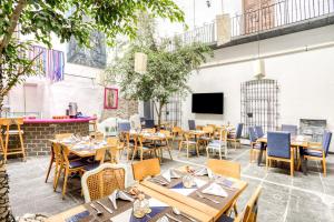 普埃布拉Milagro Hotel的餐厅设有木桌、椅子和电视。