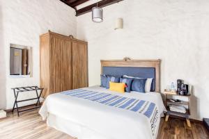 普埃布拉Milagro Hotel的一间卧室配有一张带蓝色和黄色枕头的大床