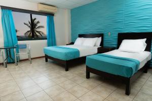蓬塔雷纳斯蓬塔雷纳斯海滩酒店的一间卧室设有两张床和蓝色的墙壁