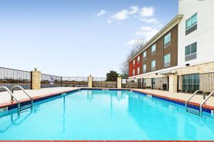 章克申Holiday Inn Express & Suites Junction, an IHG Hotel的大楼前的蓝色海水游泳池