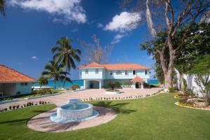 圣玛丽Edgewater Beach Villa - Beach Front, Close to All Attractions的一座大白色房子,在院子里设有一个喷泉