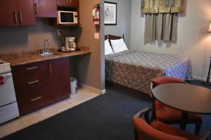 霍普Hope Inn and Suites的小房间设有床、桌子和厨房
