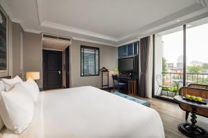 河内Solaria Hanoi Hotel的一间带一张白色大床的卧室和一个阳台