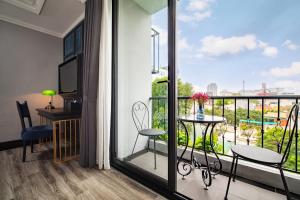河内Solaria Hanoi Hotel的客房设有带桌椅的阳台。