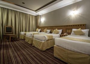 麦加EWG Rahaf Al Mashaer Hotel的酒店客房设有三张床和电视。