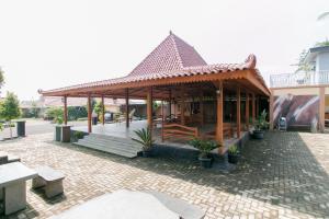展玉RedDoorz Syariah near Tugu Lampu Gentur Cianjur的砖砌庭院中带凉亭的建筑