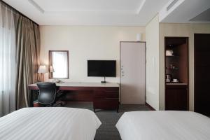 首尔江南贝斯特韦斯特尊贵酒店的酒店客房设有两张床和一张带电脑的书桌